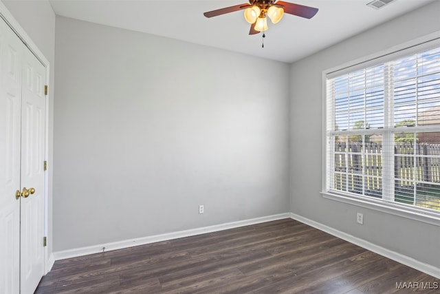 unfurnished bedroom featuring a closet, dark wood-type flooring, and ceiling fan