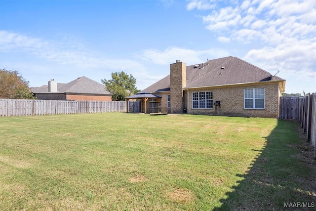 rear view of house with a yard and a gazebo