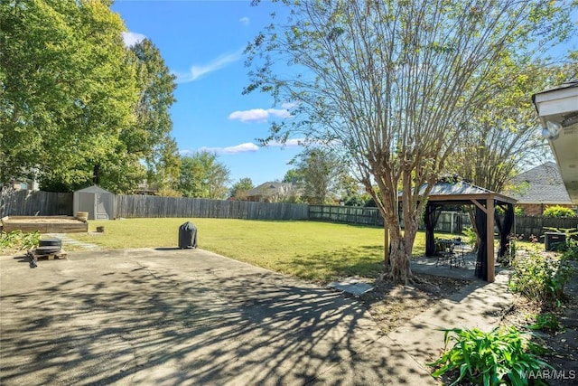 view of yard featuring a gazebo, a storage shed, and a patio area