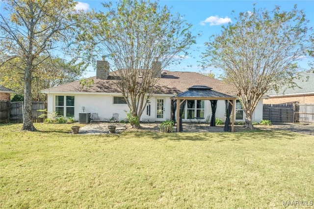 rear view of property featuring a gazebo, a patio area, central AC, and a lawn