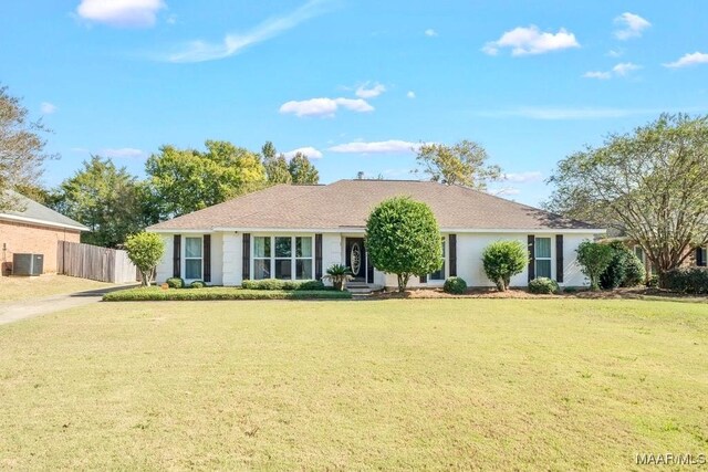 ranch-style house with a front yard and central AC unit