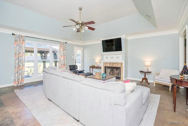 living room featuring crown molding, ceiling fan, a tray ceiling, and a tile fireplace