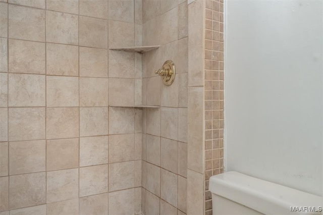 bathroom featuring tiled shower and toilet