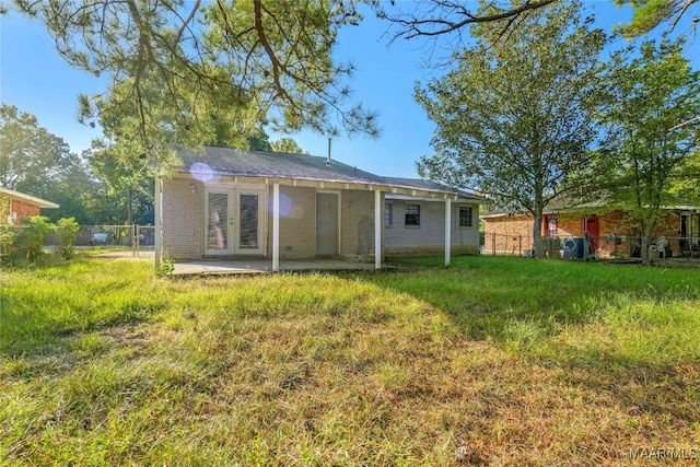 rear view of house with a patio and a yard