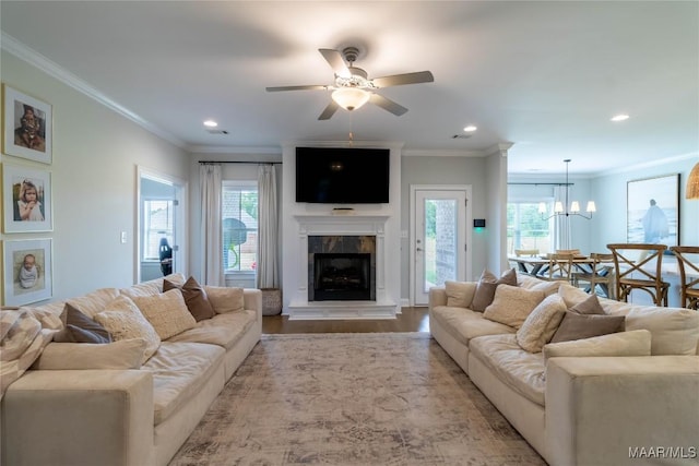 living area with a healthy amount of sunlight, recessed lighting, ceiling fan with notable chandelier, and a tile fireplace