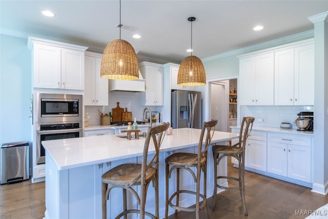 kitchen featuring white cabinetry, stainless steel appliances, and pendant lighting