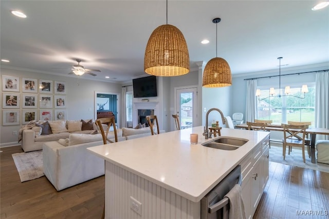 kitchen featuring dark wood finished floors, light countertops, dishwasher, a sink, and a ceiling fan