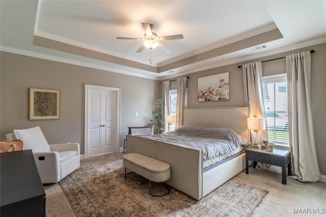 carpeted bedroom featuring visible vents, a raised ceiling, ceiling fan, and ornamental molding