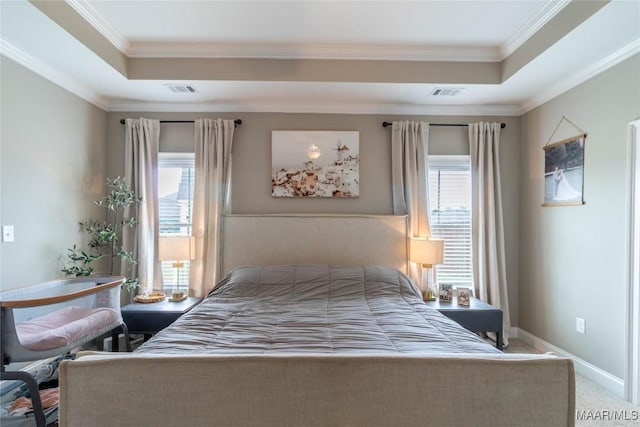 bedroom with ornamental molding, carpet floors, and a tray ceiling