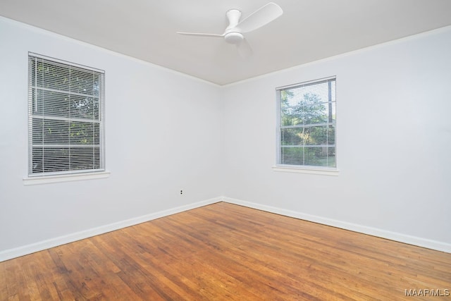 empty room featuring ornamental molding, wood-type flooring, and ceiling fan