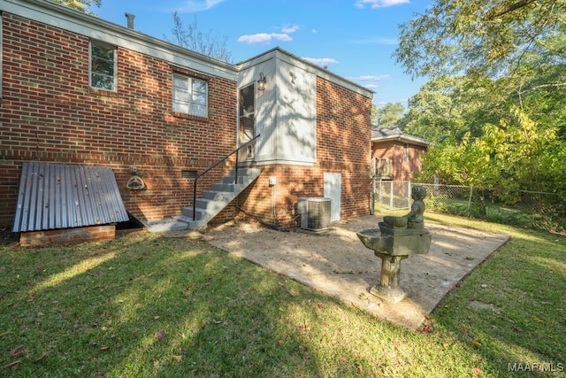 rear view of property featuring a yard and central AC