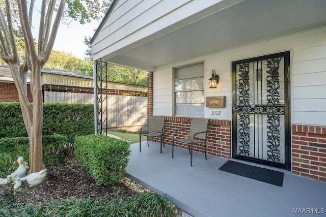 3712 Ware Ct, Montgomery, AL 36109 - view of exterior entry featuring a porch, brick siding, and fence