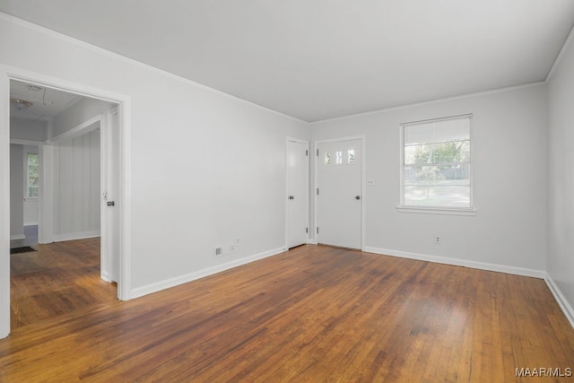 foyer with ornamental molding and dark wood-type flooring