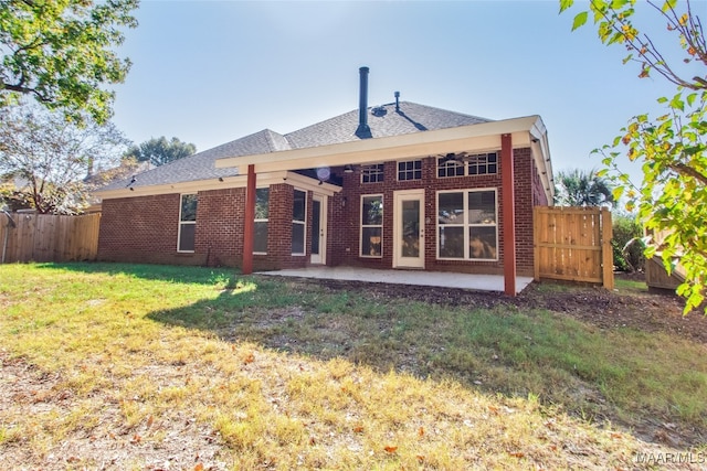 rear view of property featuring a patio area and a lawn