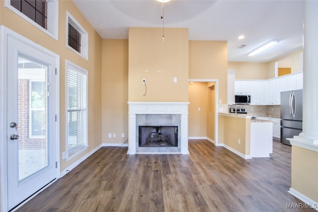 unfurnished living room featuring sink, a fireplace, and hardwood / wood-style flooring