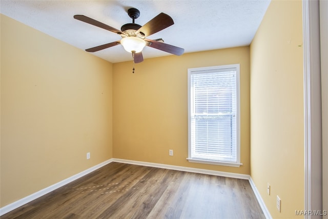 empty room with a textured ceiling, wood-type flooring, and ceiling fan