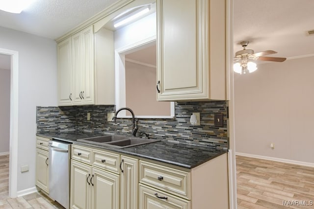 kitchen with stainless steel dishwasher, sink, light wood-type flooring, and backsplash