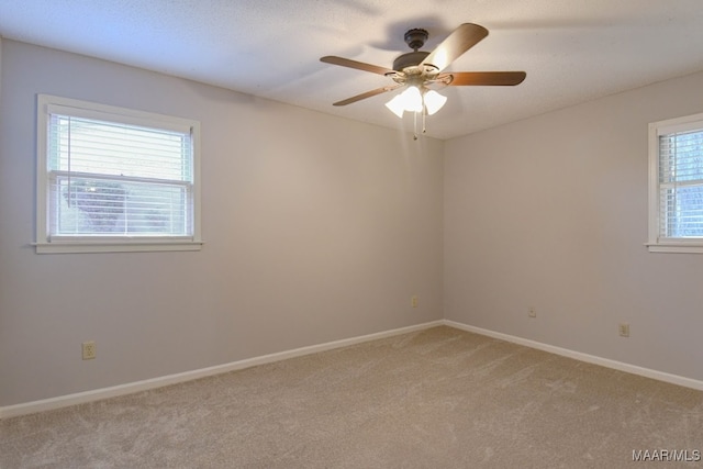 carpeted spare room with a textured ceiling and ceiling fan