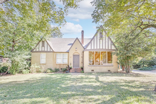 tudor-style house with a front lawn