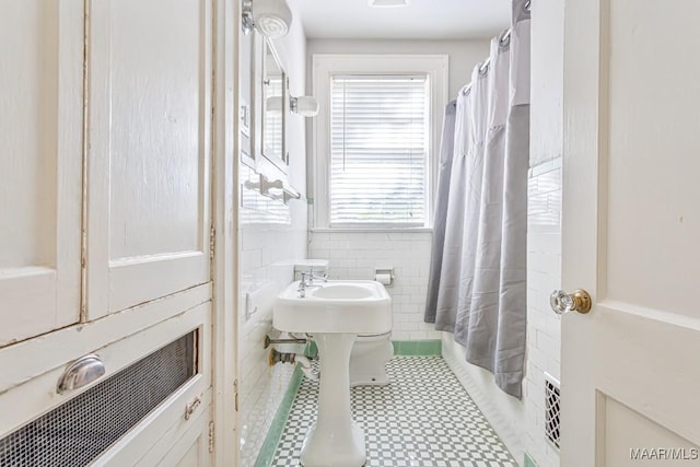 full bath with tile walls and curtained shower
