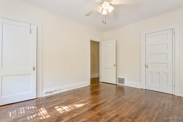 unfurnished bedroom featuring visible vents, ornamental molding, baseboards, and wood finished floors
