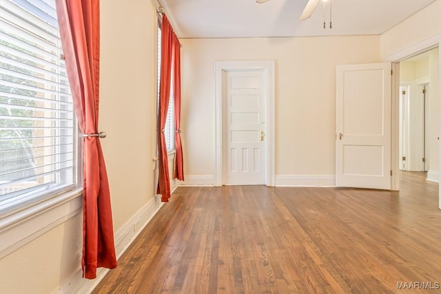 spare room with baseboards, a ceiling fan, and wood finished floors