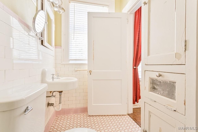 bathroom with tile walls and toilet