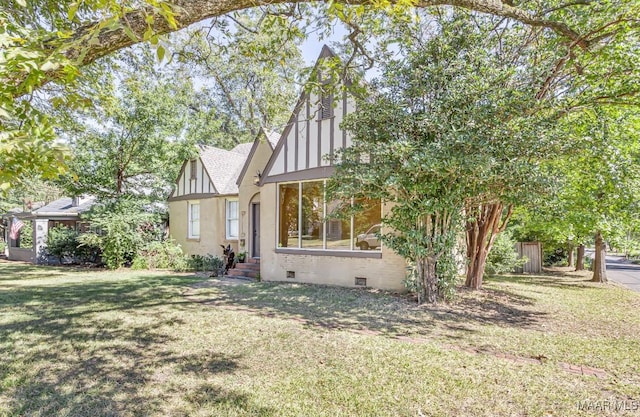 exterior space featuring a shingled roof, board and batten siding, crawl space, and a front yard