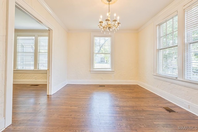 unfurnished dining area featuring a chandelier, visible vents, ornamental molding, and wood finished floors