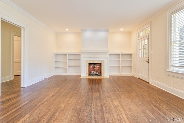 unfurnished living room with a healthy amount of sunlight, ornamental molding, dark hardwood / wood-style flooring, and a tile fireplace