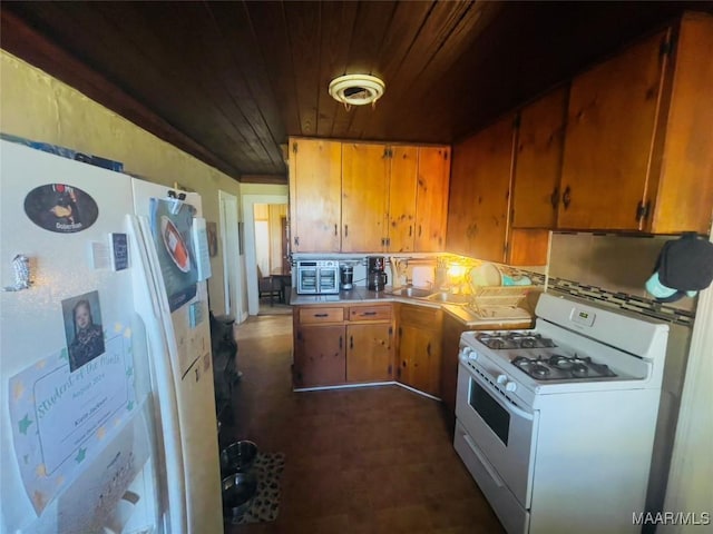 895 Lamar Rd, Hope Hull, AL 36043 - kitchen with white appliances, wooden ceiling, brown cabinets, dark flooring, and light countertops