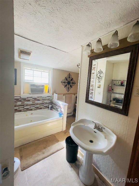 895 Lamar Rd, Hope Hull, AL 36043 - bathroom with a jetted tub, a textured ceiling, and tile patterned floors