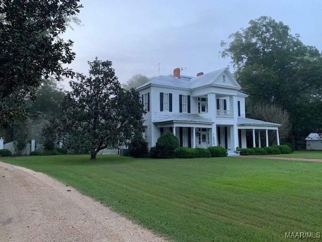 neoclassical home featuring a porch and a front yard