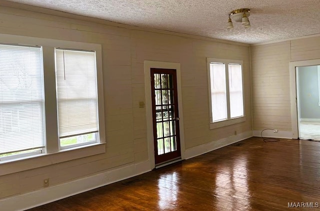 foyer with a textured ceiling, dark hardwood / wood-style floors, and a healthy amount of sunlight