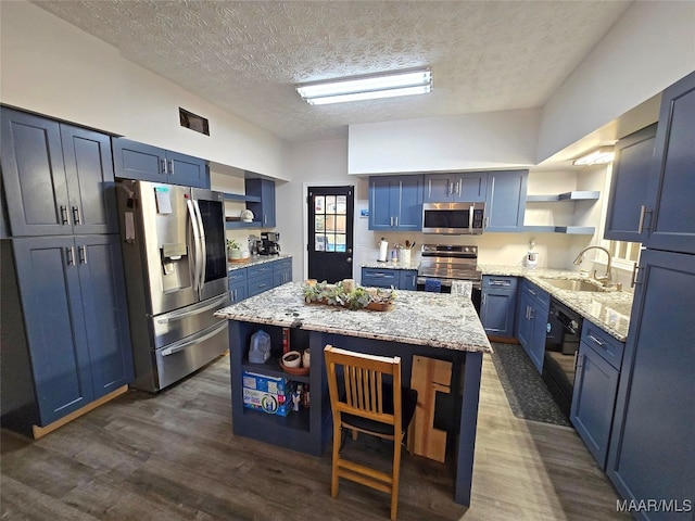 kitchen featuring sink, dark hardwood / wood-style floors, blue cabinets, a textured ceiling, and appliances with stainless steel finishes