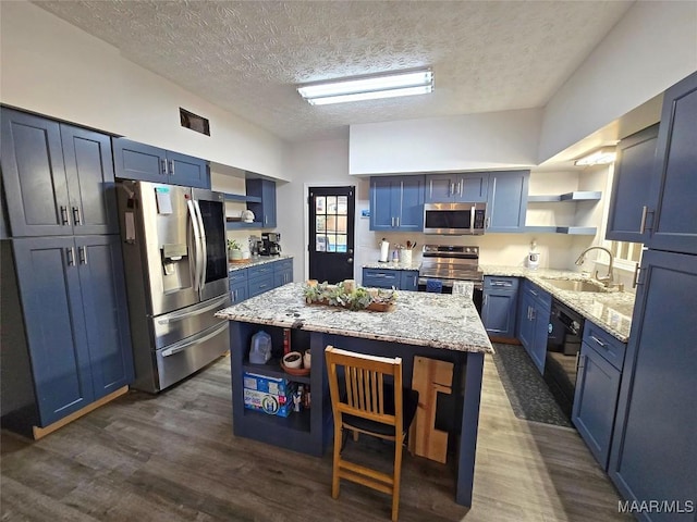 kitchen with a kitchen island, blue cabinets, stainless steel appliances, open shelves, and a sink