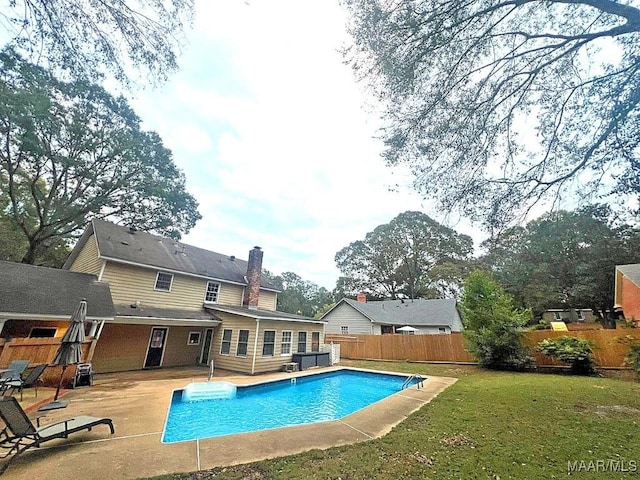 view of swimming pool featuring a lawn, a patio area, fence, and a fenced in pool