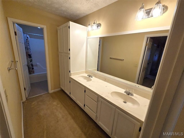 bathroom with double vanity, a textured ceiling, a sink, and shower / tub combo with curtain