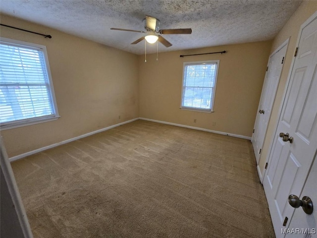 unfurnished bedroom featuring a textured ceiling, ceiling fan, carpet, and baseboards