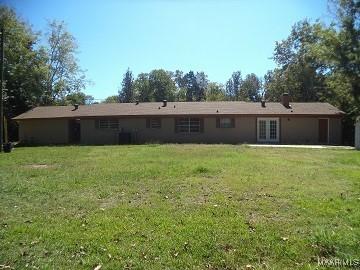 rear view of property featuring a lawn and french doors