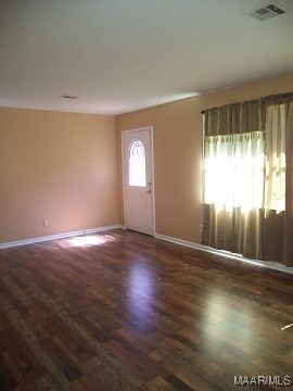 foyer with a textured ceiling and dark wood-type flooring