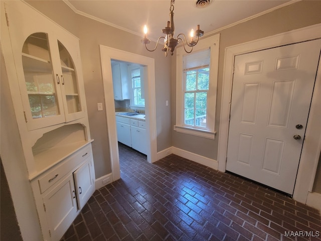 unfurnished dining area with crown molding, sink, and a notable chandelier