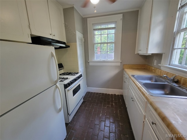 kitchen featuring a healthy amount of sunlight, sink, white cabinetry, and white appliances