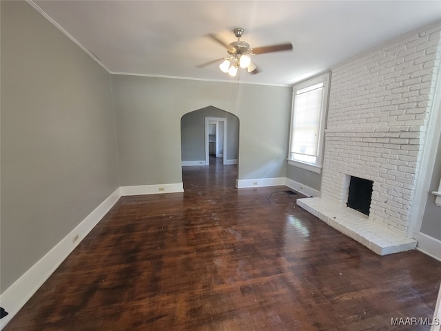 unfurnished living room with crown molding, dark hardwood / wood-style flooring, a fireplace, and ceiling fan