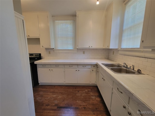 kitchen featuring tasteful backsplash, dark hardwood / wood-style flooring, white cabinetry, black range, and sink