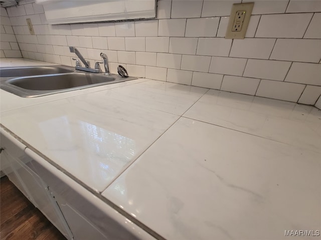 interior space with decorative backsplash, sink, and dark hardwood / wood-style flooring