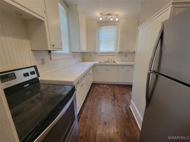 kitchen with white cabinetry, stainless steel refrigerator, dark wood-type flooring, and black electric range oven