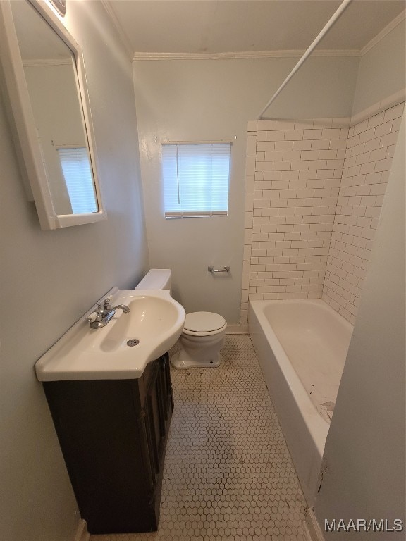 full bathroom featuring tiled shower / bath, toilet, vanity, crown molding, and tile patterned floors