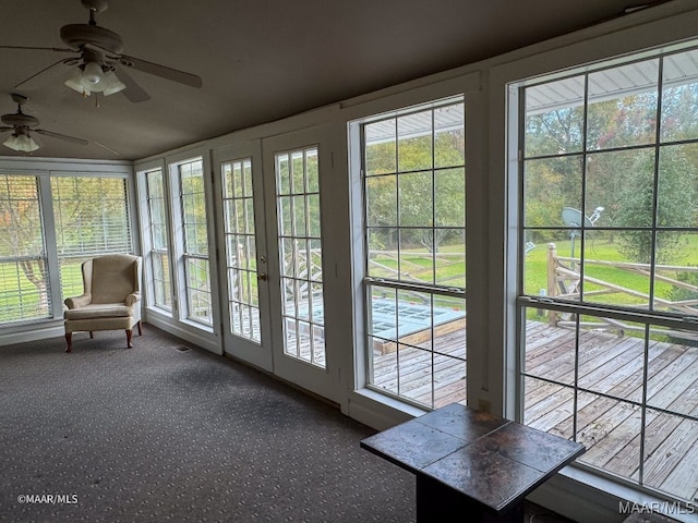 unfurnished sunroom featuring a wealth of natural light, french doors, and ceiling fan