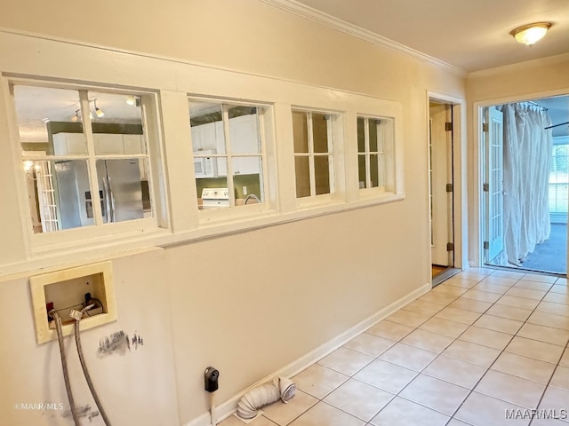 laundry room featuring tile patterned floors, crown molding, and washer hookup